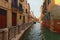 Stunning landscape view of street in Venice. Typical street with ancient building, narrow canal with turquoise water