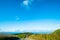 The stunning landscape of the way in a rural area in New Zealand. Gravel road among green grassland with blue sky. I