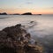 Stunning landscapedawn sunrise with rocky coastline and long exp