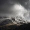 Stunning moody dramatic Winter landscape image of snowcapped Tryfan mountain in Snowdonia with stormy weather brooding overhead