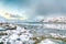 Stunning morning view of Torsfjorden fjord with cracked ice and snowy mountain peaks at background