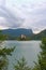 Stunning nature landscape of Bled Lake with St. Marys Church of Assumption on small island. Natural frame form green leaves