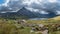 Stunning panoramic landscape image of countryside around Llyn Ogwen in Snowdonia during early Autumn with Tryfan in background