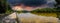 A stunning panoramic shot of the silky brown water of the Chattahoochee river surrounded by lush green trees