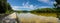 A stunning panoramic shot of the vast still silky brown water of the Chattahoochee river with a long wooden boardwalk