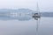 Stunning peaceful landscape image of misty Spring morning over Windermere in Lake District and distant misty peaks