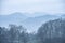 Stunning peaceful landscape image of misty Spring morning over Windermere in Lake District and distant misty peaks