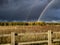 A stunning rainbow against dark clouds over rural fields in Suffolk