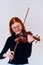 Stunning Redhead Musician Poses with Violin in Captivating Portrait