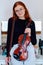 Stunning Redhead Musician Poses with Violin in Captivating Portrait