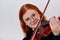 Stunning Redhead Musician Poses with Violin in Captivating Portrait