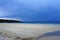 Stunning reflection of sunlight at the beach when rainclouds are forming above the sea