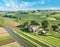 Stunning rural setting featuring a sprawling farm surrounded by lush green fields, AI-generated.