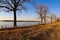 A stunning shot of the blue running waters of the Mississippi river with bare trees and brown and yellow grass