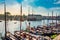 Stunning shot of many moored sailboats with Amsterdam modern traditional buildings in the background