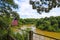 A stunning shot of the silk brown waters of the Chattahoochee river surrounded by lush green trees with an American flag