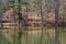 A stunning shot of the silky green waters of Sibley Pond surrounded by lush green trees and bare winter trees