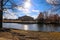 A stunning shot of the still blue lake water surrounded by gorgeous autumn trees in the park with a view of The Parthenon