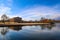 A stunning shot of the still blue lake water surrounded by gorgeous autumn trees in the park with a view of The Parthenon