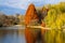 A stunning shot of the still blue waters of the lake in the park surrounded by gorgeous autumn colored trees