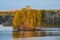 A stunning shot of the still blue waters of the lake at Stone Mountain park with lush green and autumn colored trees reflecting of