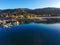 A stunning shot of the still lake waters and sand beach with majestic mountain ranges with blue sky