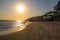 A stunning shot of the sunset and the ocean and the rock and people walking on the beach at El Matador beach