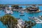 A stunning shot of the vast blue ocean water with white boats and yachts docked in the harbor and sailing in the harbor