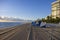 a stunning summer landscape along the beach at sunrise with blue and white lounge chairs, blue ocean water, palm trees, hotels