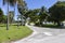 a stunning summer landscape at Crandon Park along a footpath with lush green palm trees and grass, people walking