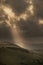 Stunning Summer landscape image of escarpment with dramatic storm clouds and sun beams streaming down