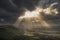 Stunning Summer landscape image of escarpment with dramatic storm clouds and sun beams streaming down