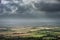 Stunning Summer landscape image of escarpment with dramatic storm clouds and sun beams streaming down