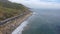 A stunning summer landscape at long the coastline with vast blue ocean water and waves rolling into the shore