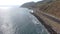 A stunning summer landscape at long the coastline with vast blue ocean water and waves rolling into the shore