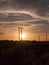 Stunning sun set over field and metal wooden poles electricity t