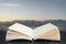 Stunning sunrise landscape over rocks in sea coming out of pages in imaginary reading book