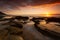 Stunning sunrise over the ocean, rocks and rock pools