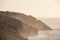 Stunning sunset landscape image of Cornwall cliff coastline with tin mines in background viewed from Pendeen Lighthouse headland