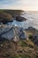 Stunning sunset landscape image of Cornwall cliff coastline with tin mines in background viewed from Pendeen Lighthouse headland