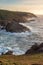 Stunning sunset landscape image of Cornwall cliff coastline with tin mines in background viewed from Pendeen Lighthouse headland