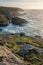 Stunning sunset landscape image of Cornwall cliff coastline with tin mines in background viewed from Pendeen Lighthouse headland