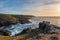 Stunning sunset landscape image of Cornwall cliff coastline with tin mines in background viewed from Pendeen Lighthouse headland