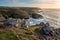 Stunning sunset landscape image of Cornwall cliff coastline with tin mines in background viewed from Pendeen Lighthouse headland