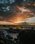 Stunning sunset over a rocky beach shoreline, with the glistening ocean waters in the background