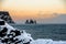 Stunning sunset in Reynisfjara volcanic beach in winter. Frozen basalt sculpture columns raise up from the sea. Iceland, Europe