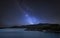 Stunning vibrant Milky Way composite image over landscape of calm lake with boat on shore