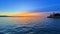 Stunning view of a distant island silhouetted against a beautiful orange and pink sky at sunset