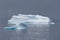 Stunning view of a group of penguins standing atop a snow-covered iceberg in Antarctica