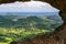 Stunning view through a rock window at the summit of famous Pali Puka hiking trail on the island of Oahu, Hawaii, USA. The dangero